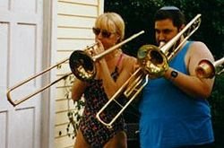 Musician on left with slide trombone; on right with valve trombone.